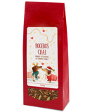 Rooibos Chai tea, 100g, in a red bag with two festive dachshunds on the label and a clear window showing the loose tea blend.
