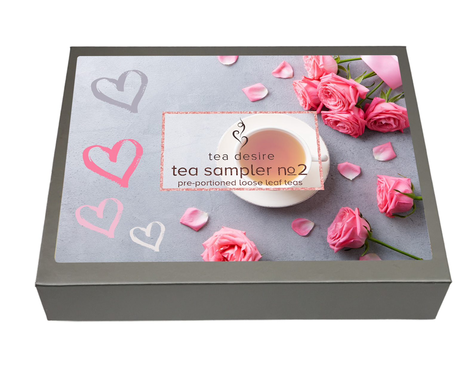 A square gray box for a tea sampler, shown at an angle on a white background. The lid features a printed design with pink roses, pink and white hearts on a light gray background, and a central label reading 'tea desire tea sampler no 2 pre-portioned love leaf tea'.