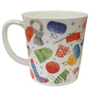 White mug with colourful yarn and knitting pattern on a white background