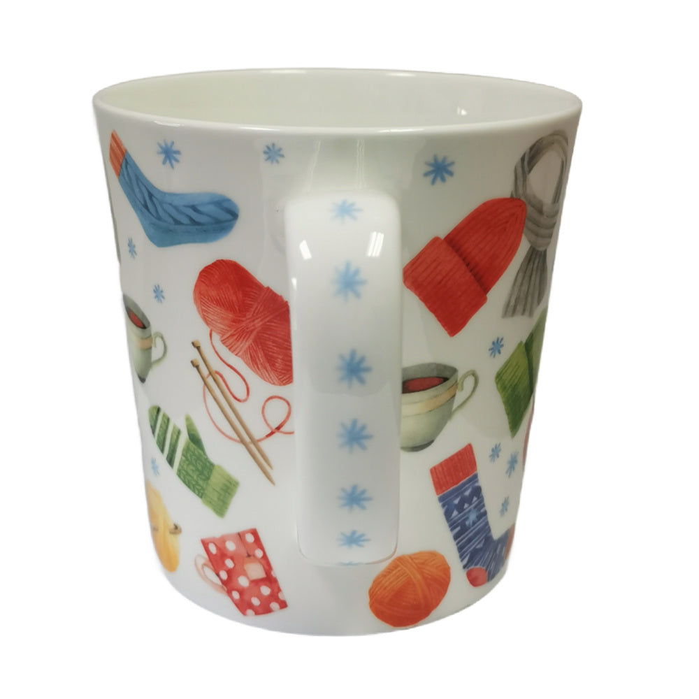 White mug with colorful knitting-themed illustrations on a white background