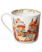 White mug with the handle on the left, showing two squirrels in winter scarves holding a green cup and a pine cone.