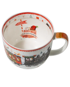 Top view of a Winter Express mug showing a train station sign and luggage illustration inside, with a miniature train around the inner rim.