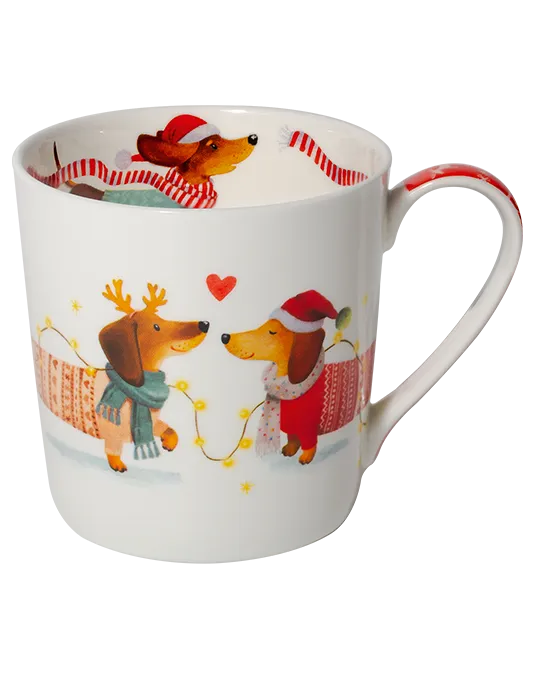 White mug featuring two dachshunds in festive knitwear, one with reindeer antlers and one in a Santa hat, surrounded by fairy lights.