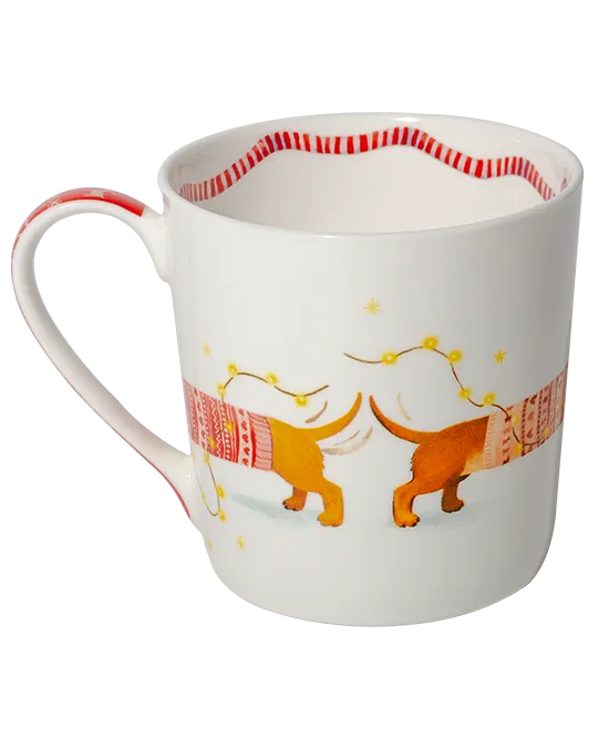 Reverse view of a white mug showing the dachshunds’ tails and patterned jumpers, with golden fairy lights and a striped border inside.