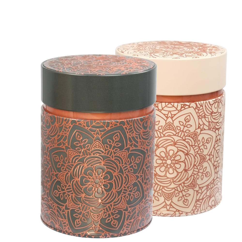 Two cylindrical containers with decorative patterns on a dark and beige background