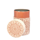 Decorative patterned container on a beige background with opened lid