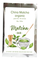 A 30g silver foil pouch of organic China Matcha green tea, featuring a white label with green text and illustrations of matcha leaves, a bamboo whisk, and a bowl of matcha powder.